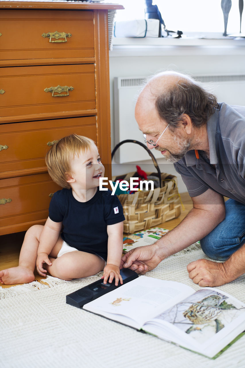 Grandfather with grandson reading book