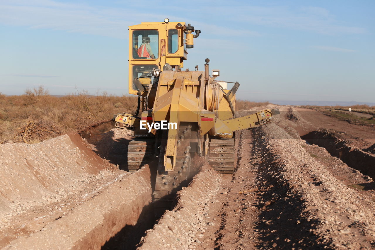 Earth mover digging in field