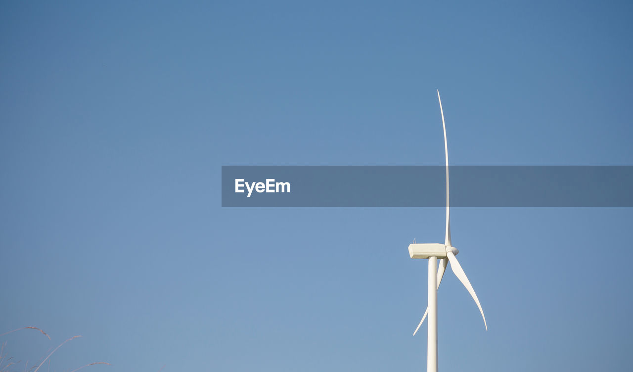 Wind turbine on field against sky