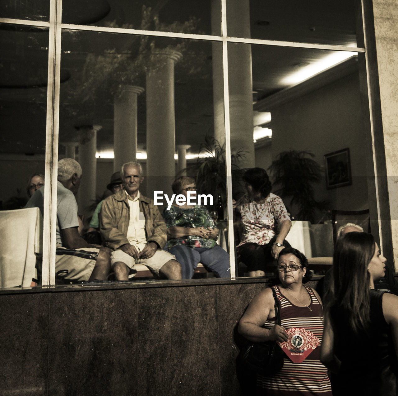 PEOPLE SITTING IN FRONT OF BUILDING AT NIGHT