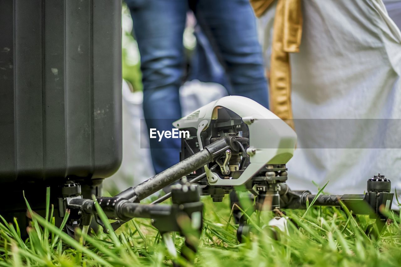 Low section of man standing by drone in back yard