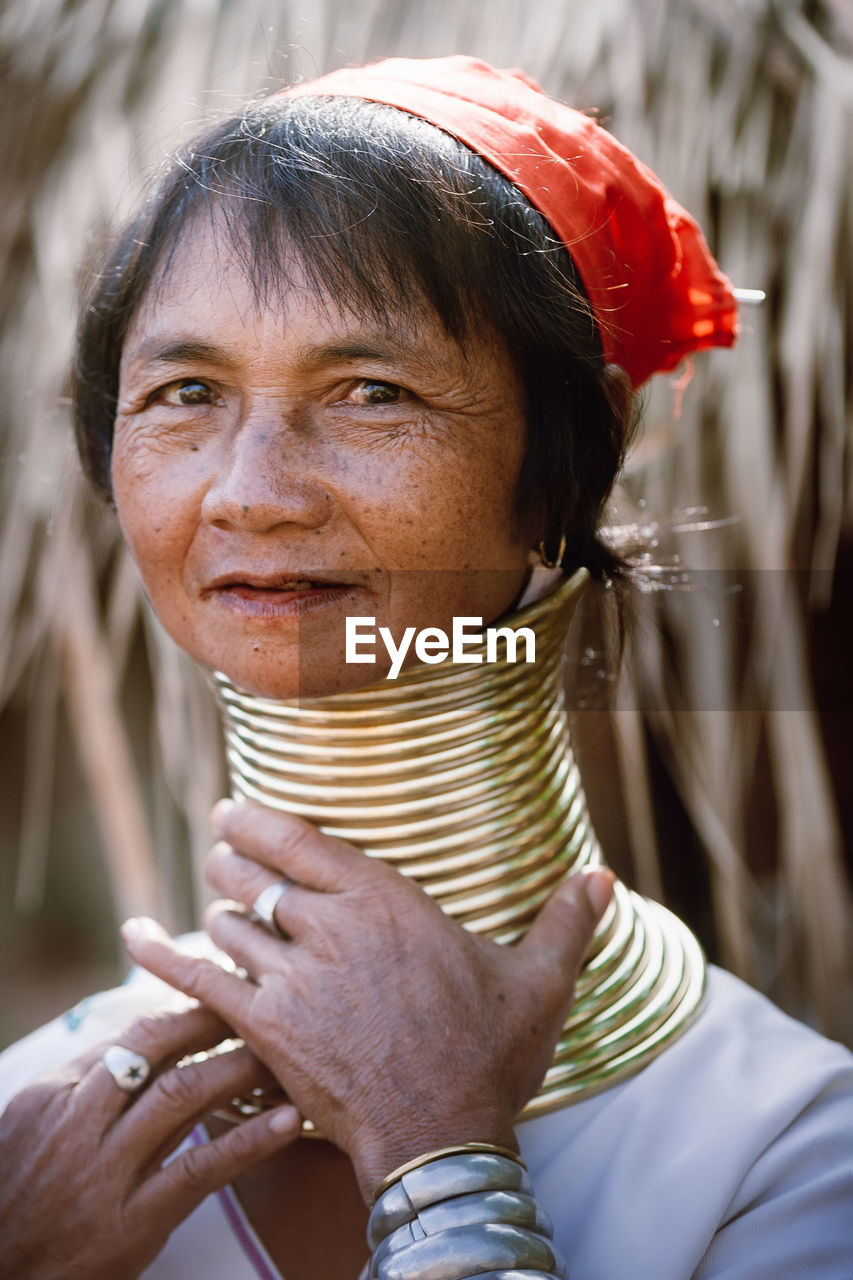 CLOSE-UP PORTRAIT OF WOMAN HOLDING A MATURE