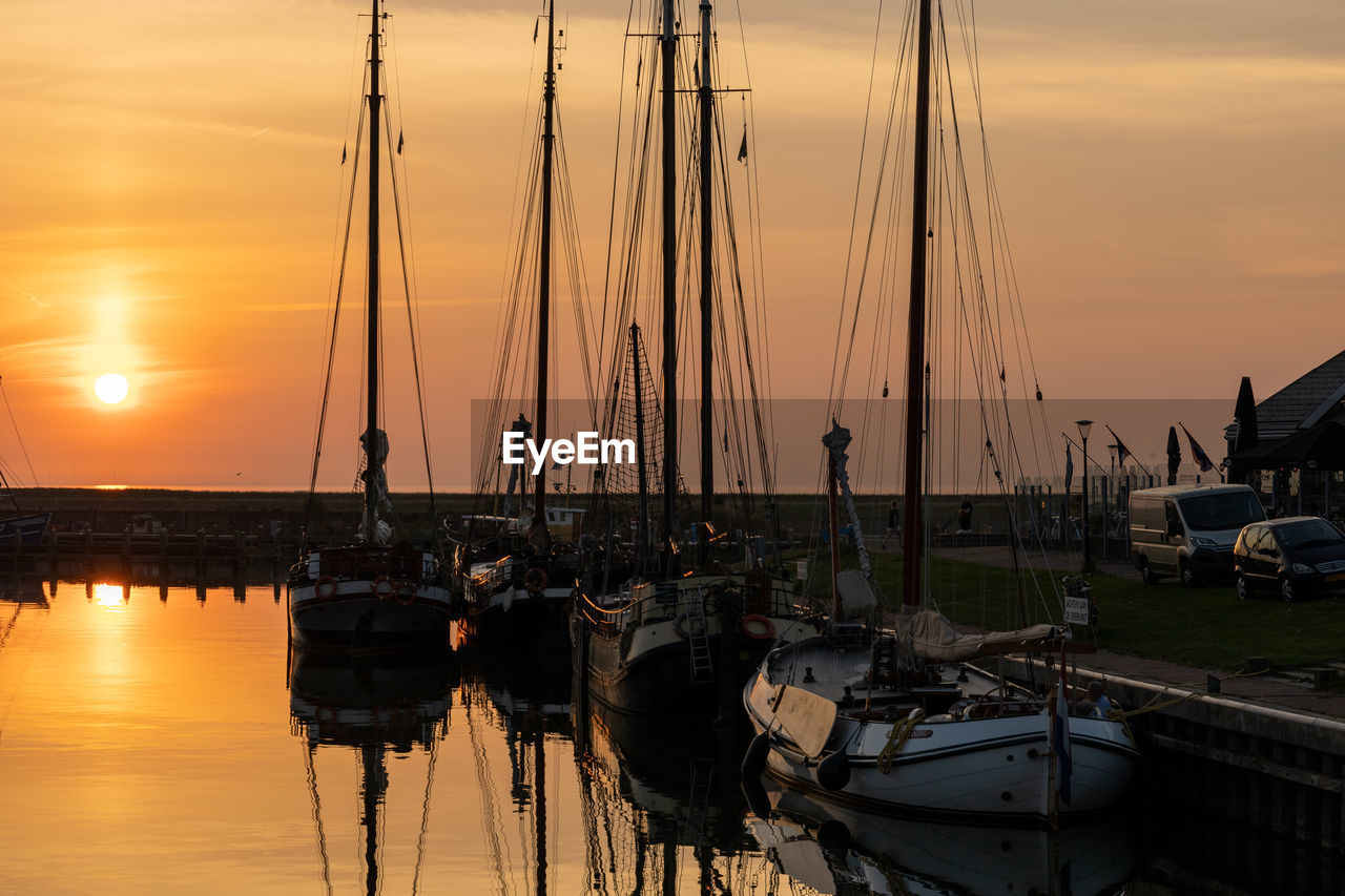 Sailboats in marina at sunset