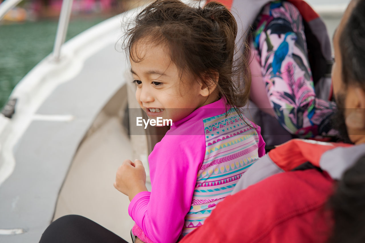 Happy toddler on a boat with family. vacation, travel and active kid concept.