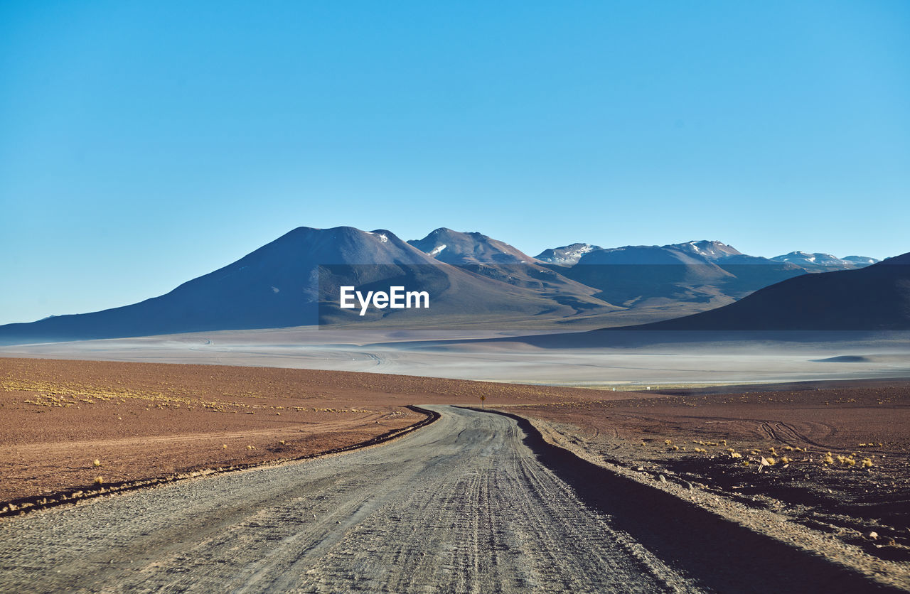 Scenic view of mountains against clear blue sky