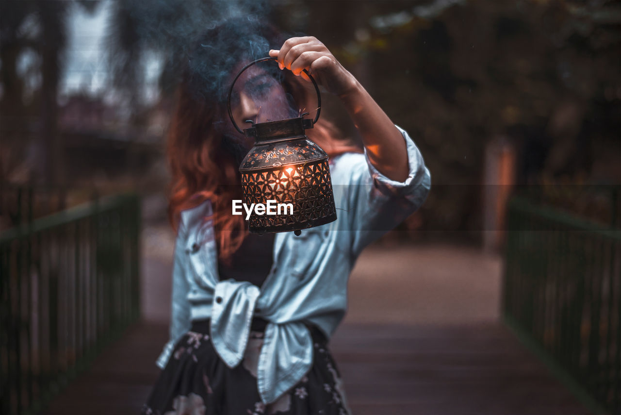 MIDSECTION OF WOMAN PHOTOGRAPHING WITH CAMERA