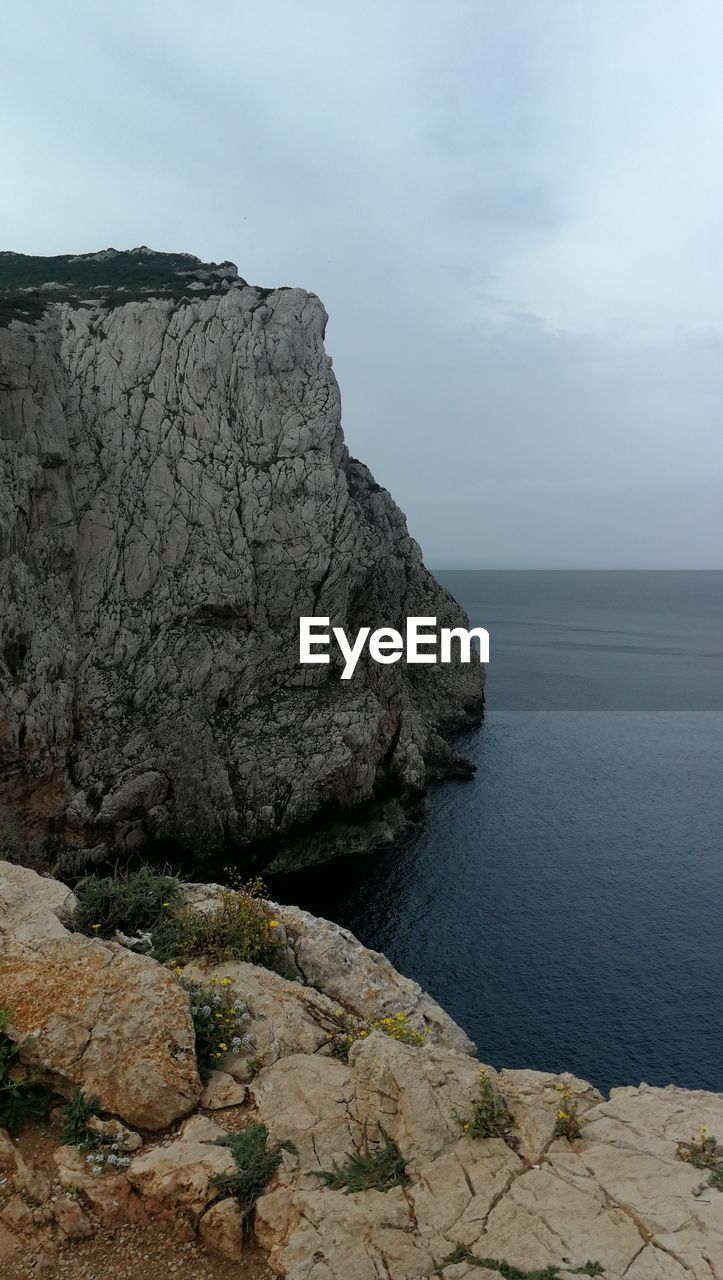 Rock formations by sea against sky