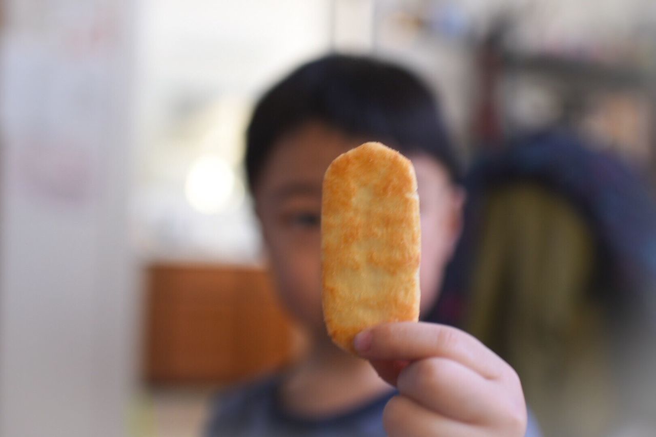 Close-up of boy holding biscuit