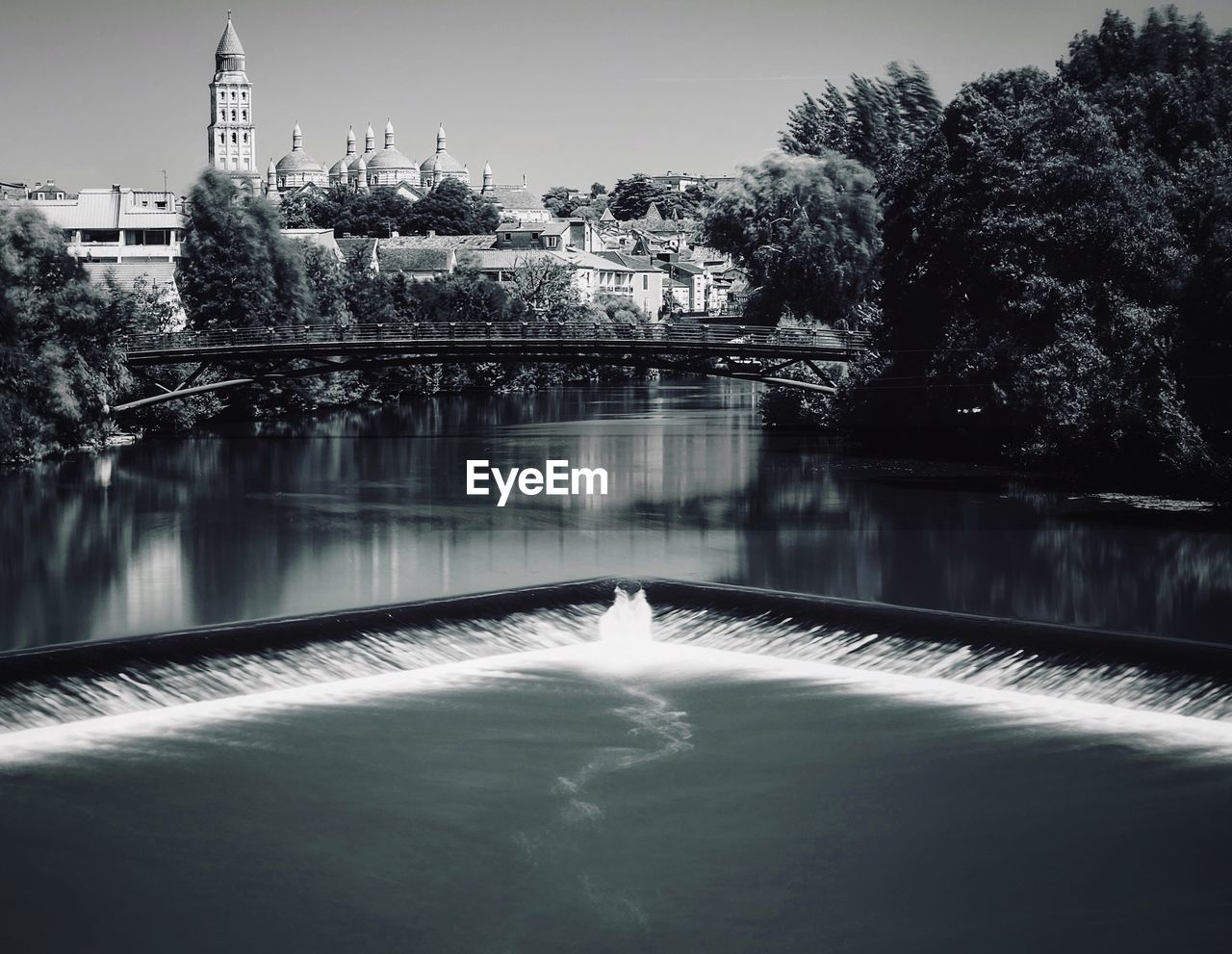 River amidst trees against saint front cathedral in city