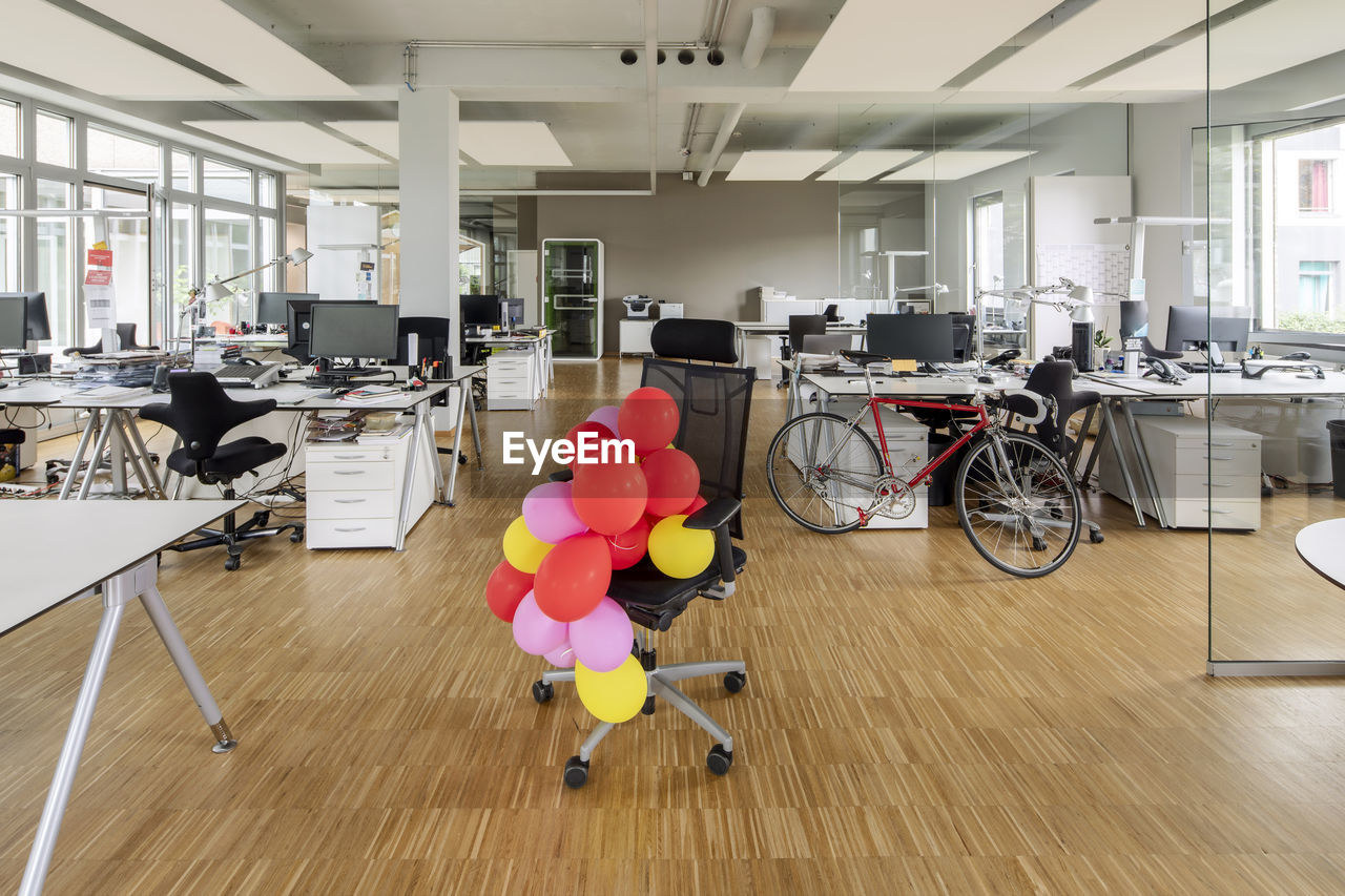 Bunch of balloons on chair in open plan office