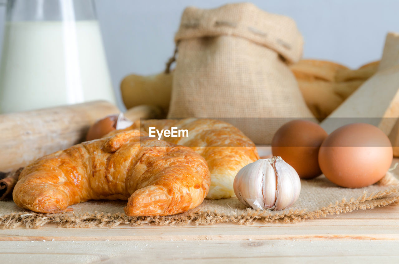 Close-up of croissant and ingredients on table