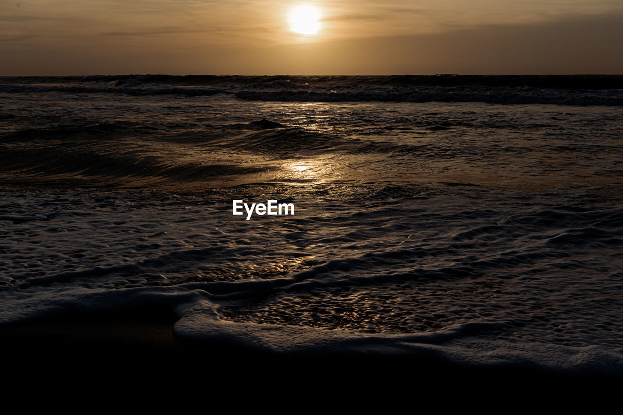 sea, water, sky, sunset, beauty in nature, land, scenics - nature, beach, nature, tranquility, ocean, horizon, wave, horizon over water, sun, motion, sunlight, wind wave, tranquil scene, reflection, cloud, idyllic, coast, dawn, no people, seascape, shore, environment, dramatic sky, outdoors, evening, sand, travel destinations, light, sports, orange color, body of water, travel, water sports, landscape, non-urban scene, holiday