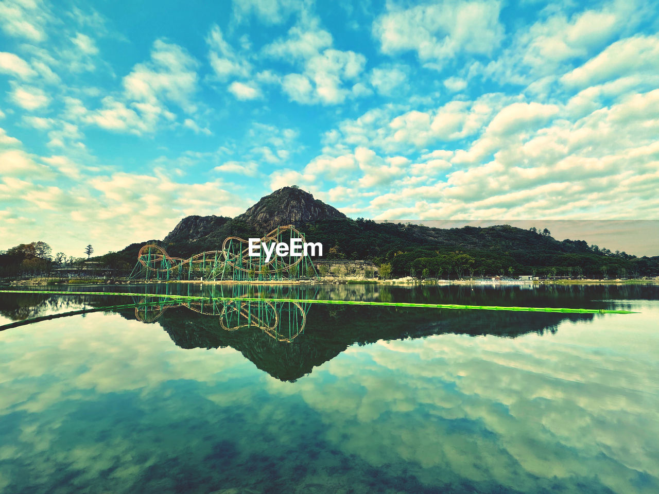 water, reflection, sky, lake, cloud, nature, scenics - nature, beauty in nature, mountain, tranquility, tranquil scene, no people, landscape, horizon, travel destinations, environment, reservoir, body of water, architecture, outdoors, travel, land, bay, day, mountain range, idyllic, blue, tree, built structure, non-urban scene, tourism
