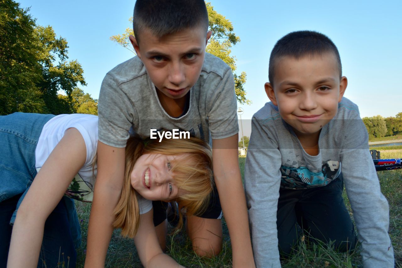 Portrait of siblings kneeling at park