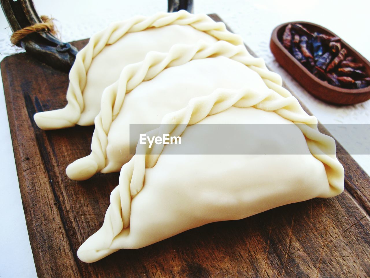 High angle view of raw empanadas on wooden plate