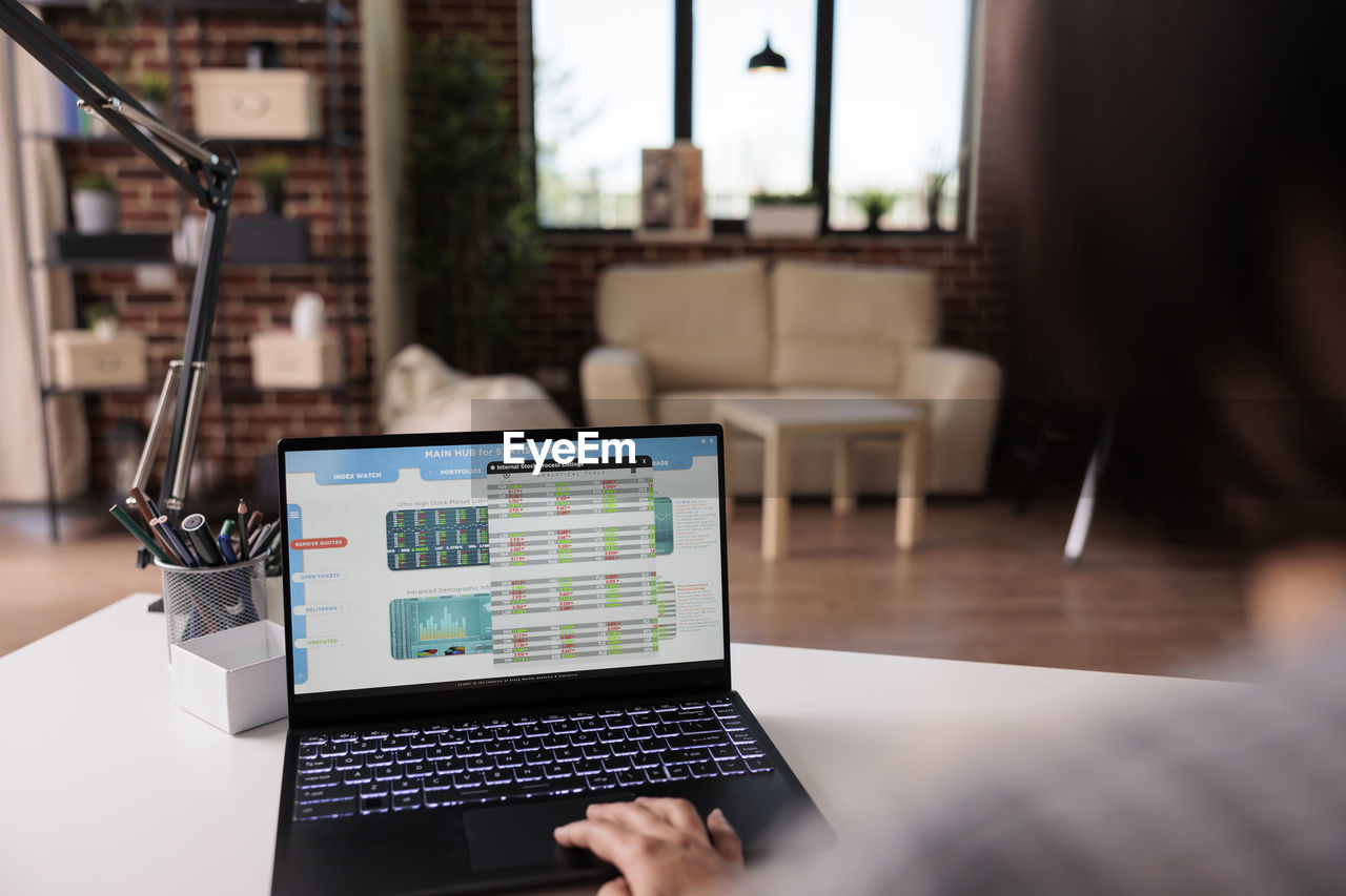 midsection of woman using laptop on table