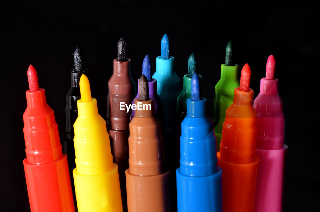 Close-up of multi colored felt tip pens against black background