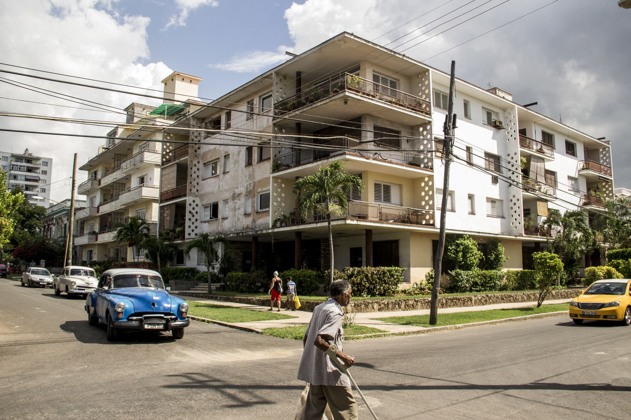 CARS ON ROAD BY BUILDINGS IN CITY