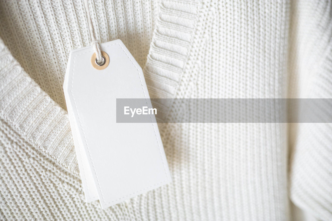 white, indoors, textile, close-up, no people, hanging, clothing, fashion accessory, outerwear