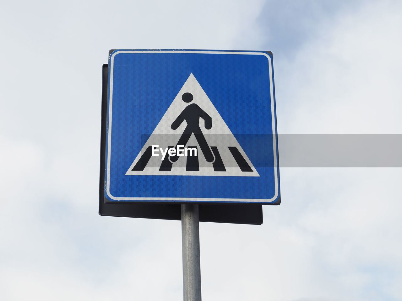 sign, communication, road, road sign, street sign, traffic sign, signage, blue, guidance, symbol, sky, warning sign, no people, cloud, representation, shape, triangle shape, transportation, nature, day, human representation, outdoors, pole, information sign, lane, low angle view, arrow symbol