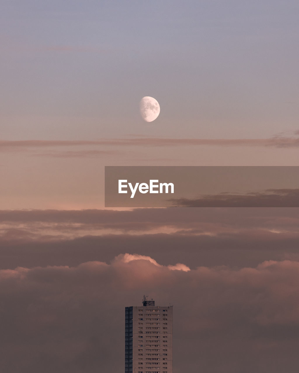 View of high rise apartment building against dusk sky.