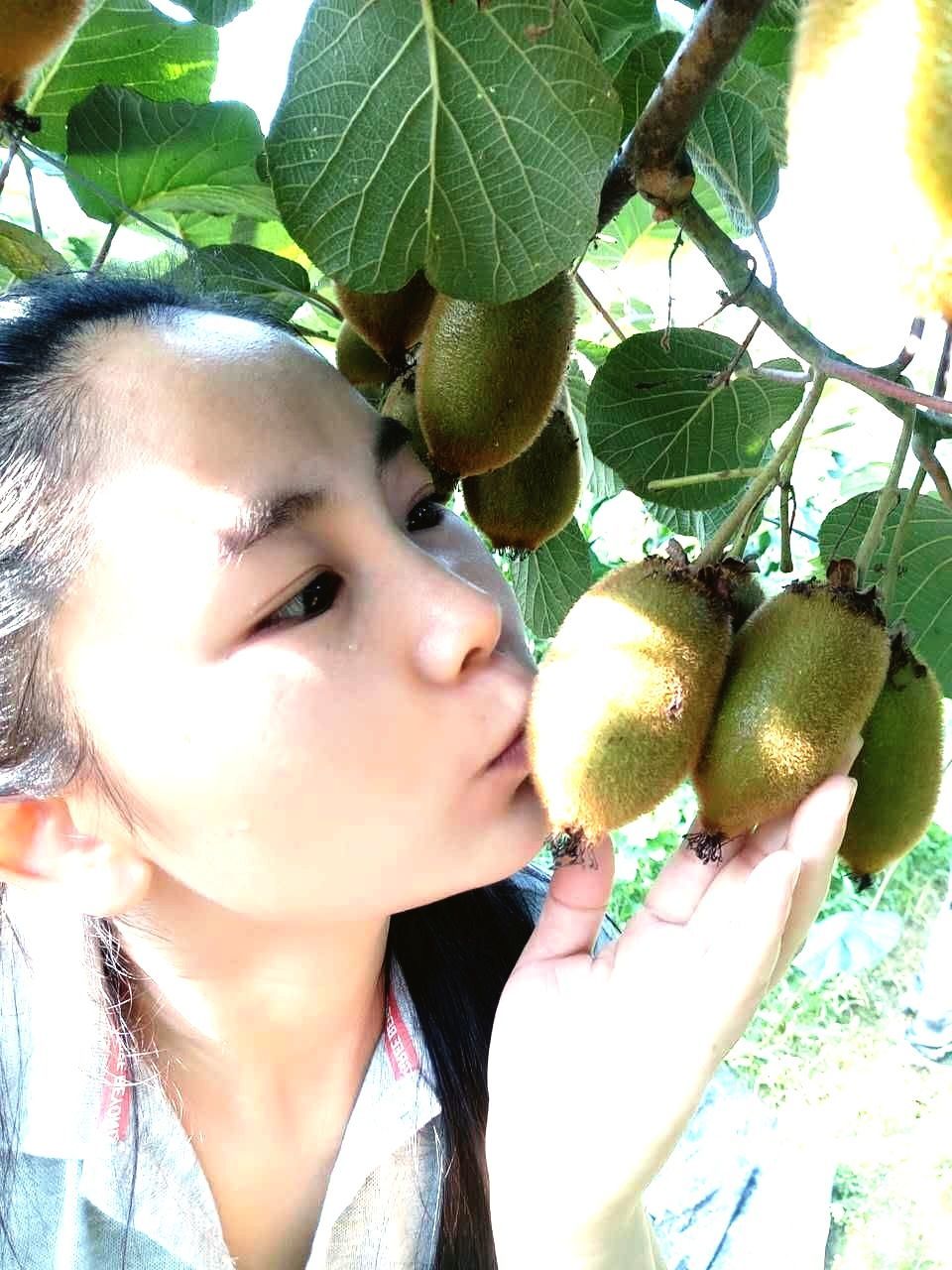 CLOSE-UP OF YOUNG WOMAN WITH FRUITS