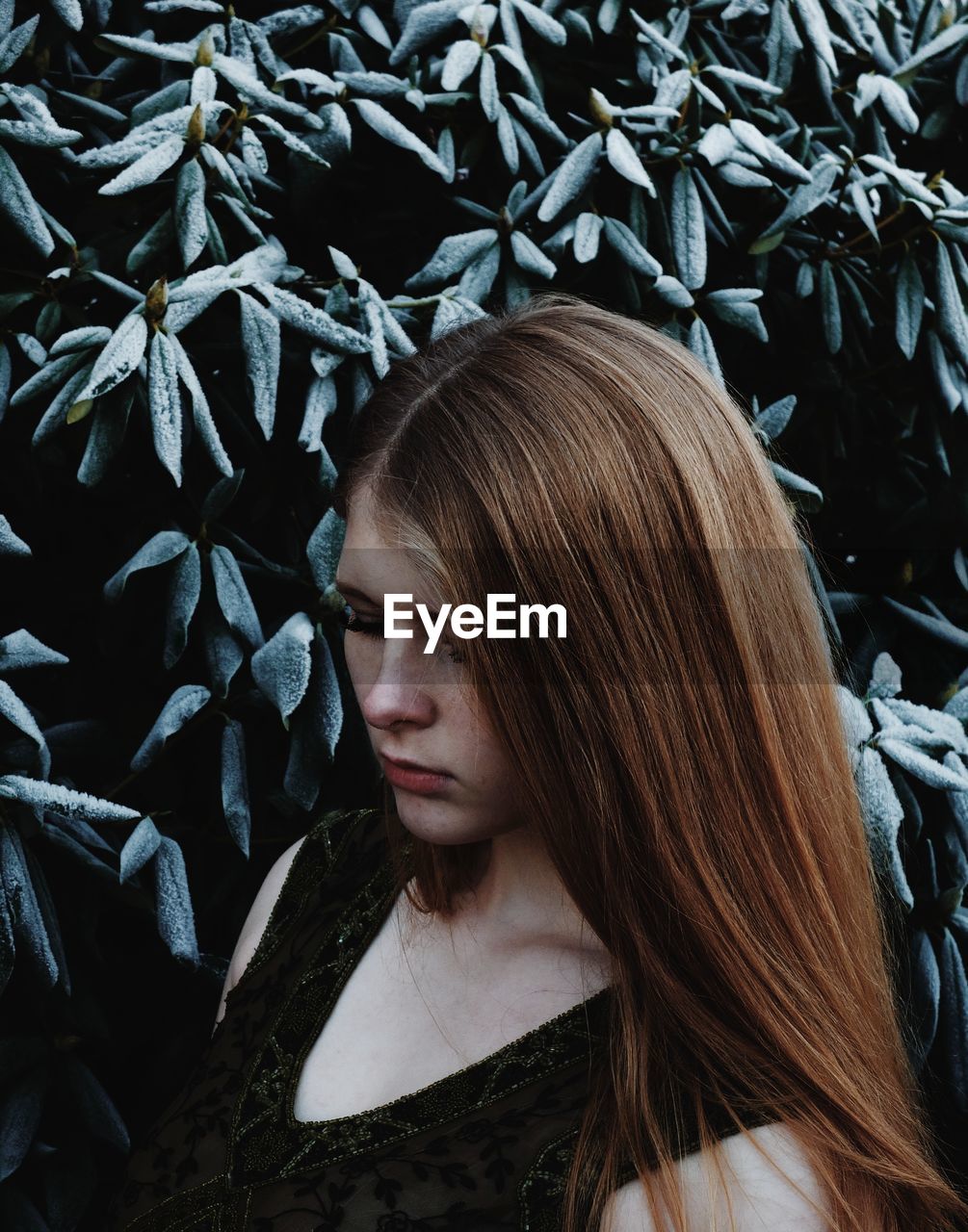 Close-up of woman standing against plant during winter