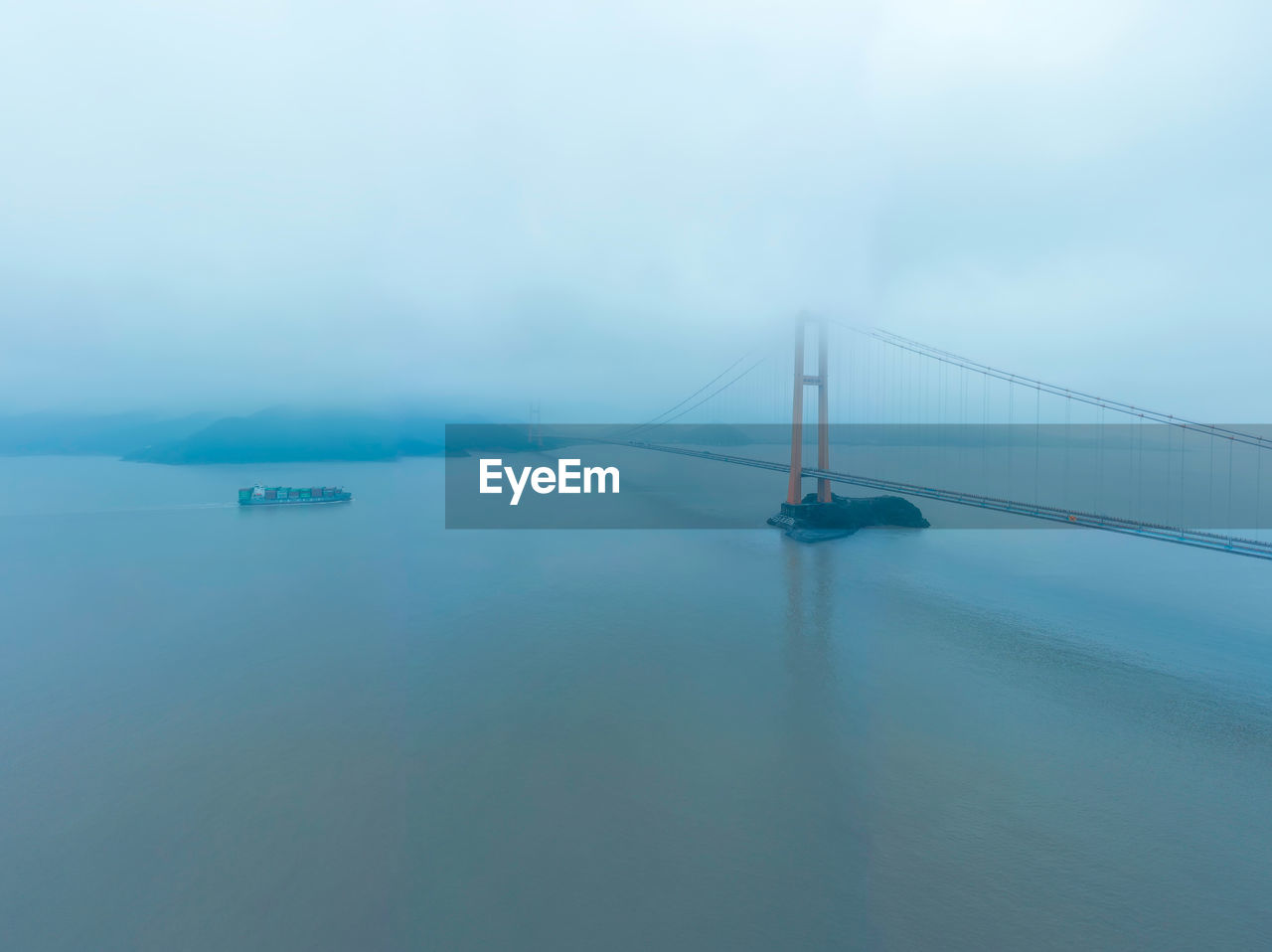 Suspension bridge over sea against sky