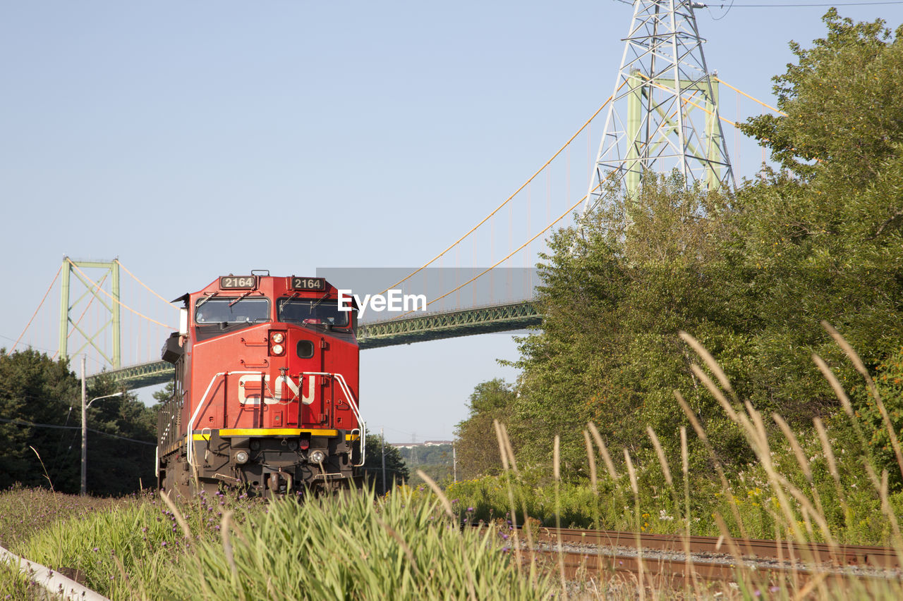 TRAIN ON RAILROAD TRACKS AGAINST SKY
