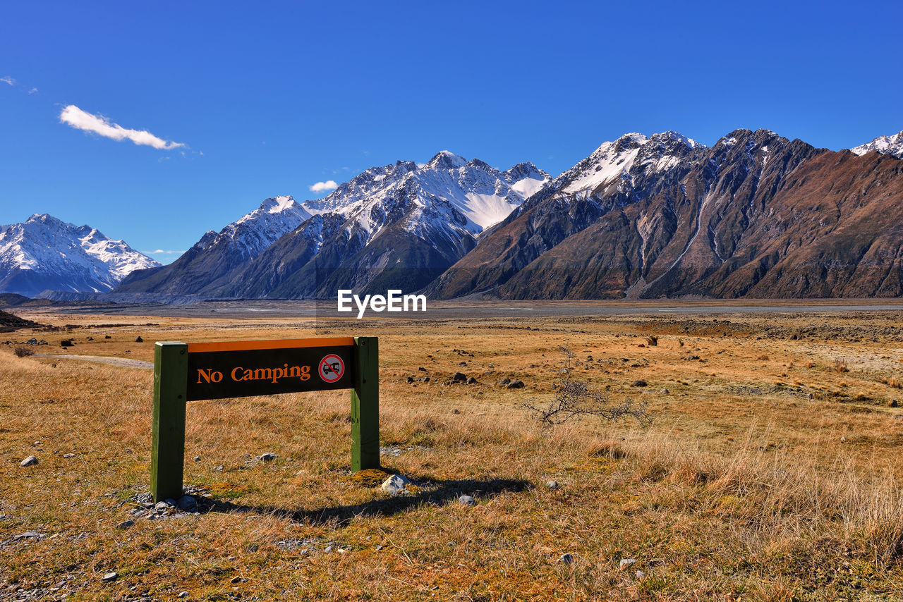 Information sign on field against sky during winter