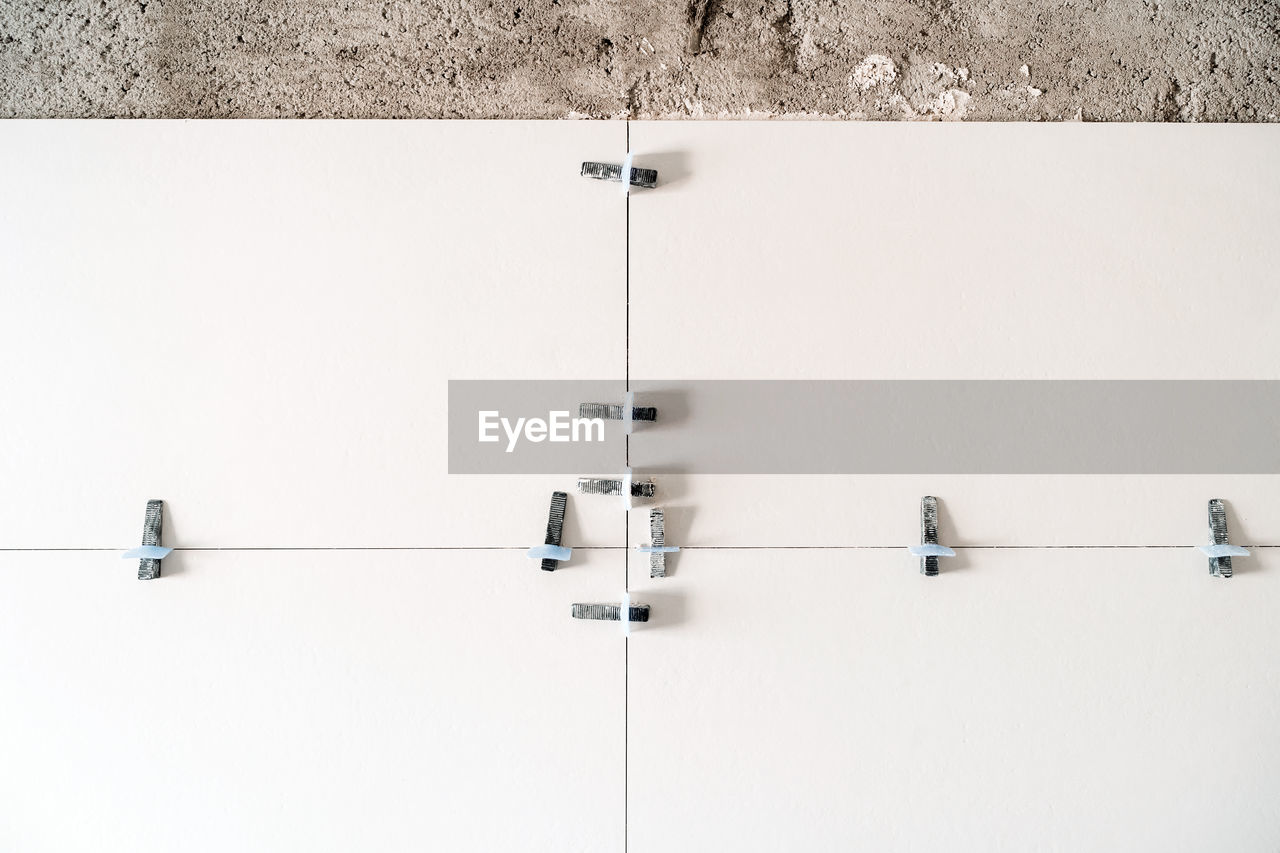 Construction site. white tiles on bathroom with separator and leveling during works. home renovation