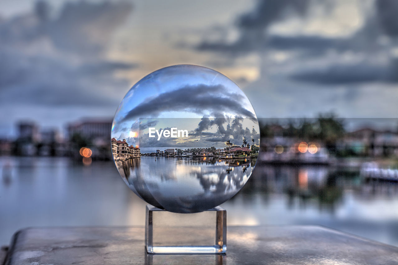 Crystal ball view of sunrise at a waterway of venetian bay in naples, florida at sunrise.