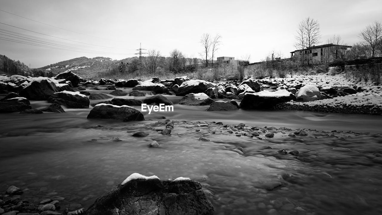 PANORAMIC VIEW OF FROZEN LAKE AGAINST SKY