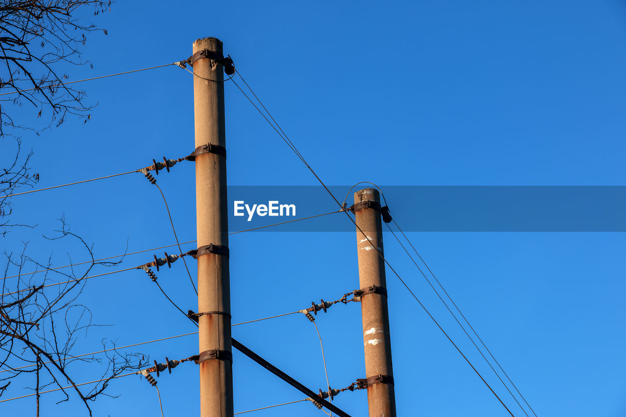 Electric pole with a linear wire against the blue sky close-up. power electric pole.
