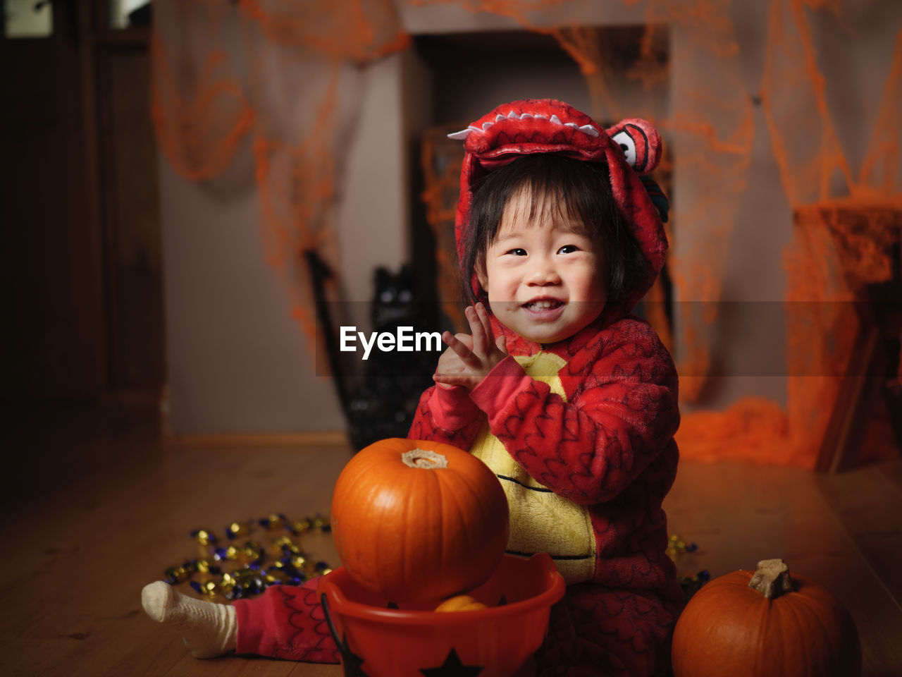 Portrait of cute baby girl in halloween costume sitting at home