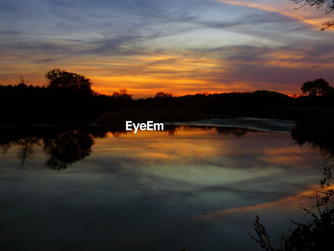 SILHOUETTE TREES BY LAKE AGAINST SKY DURING SUNSET