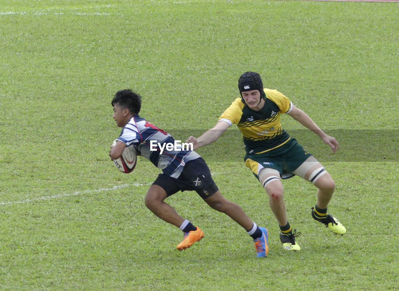 BOYS PLAYING ON GREEN FIELD