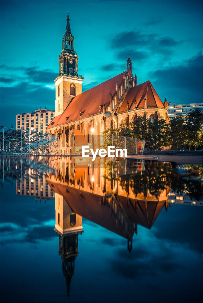 Reflection of illuminated buildings in city at dusk