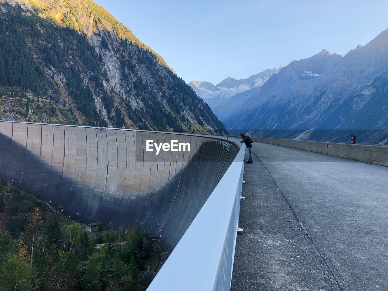 Man standing at dam against mountains