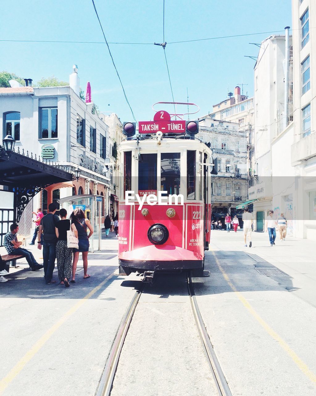 Cable car moving on tramway amidst buildings on sunny day