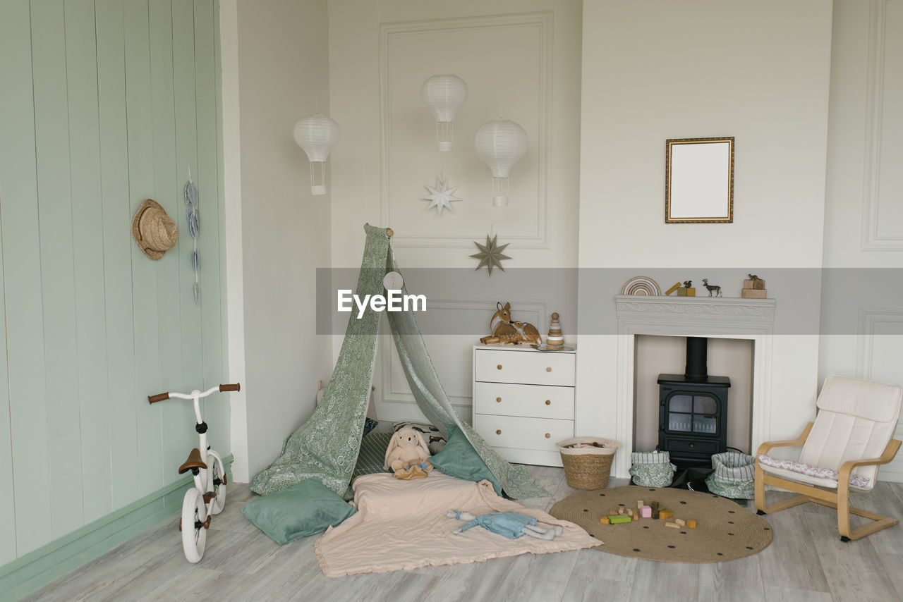 White fabric teepee and scandinavian simple decor in the interior of the children's room.