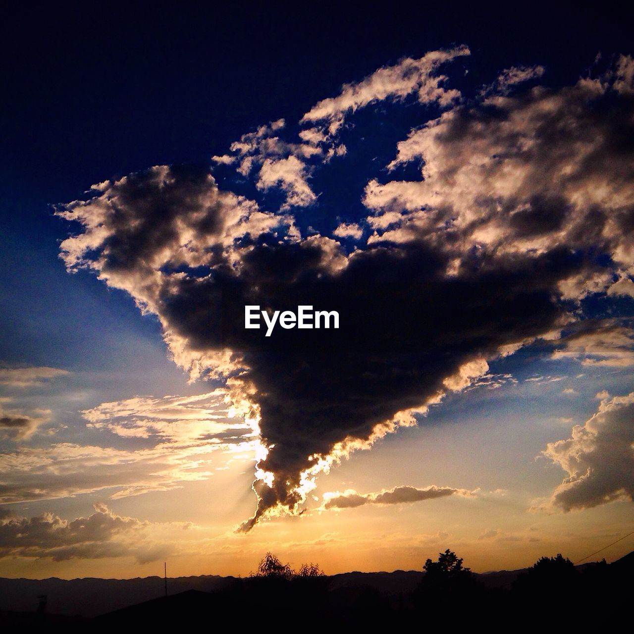 Silhouette of landscape against cloudy sky