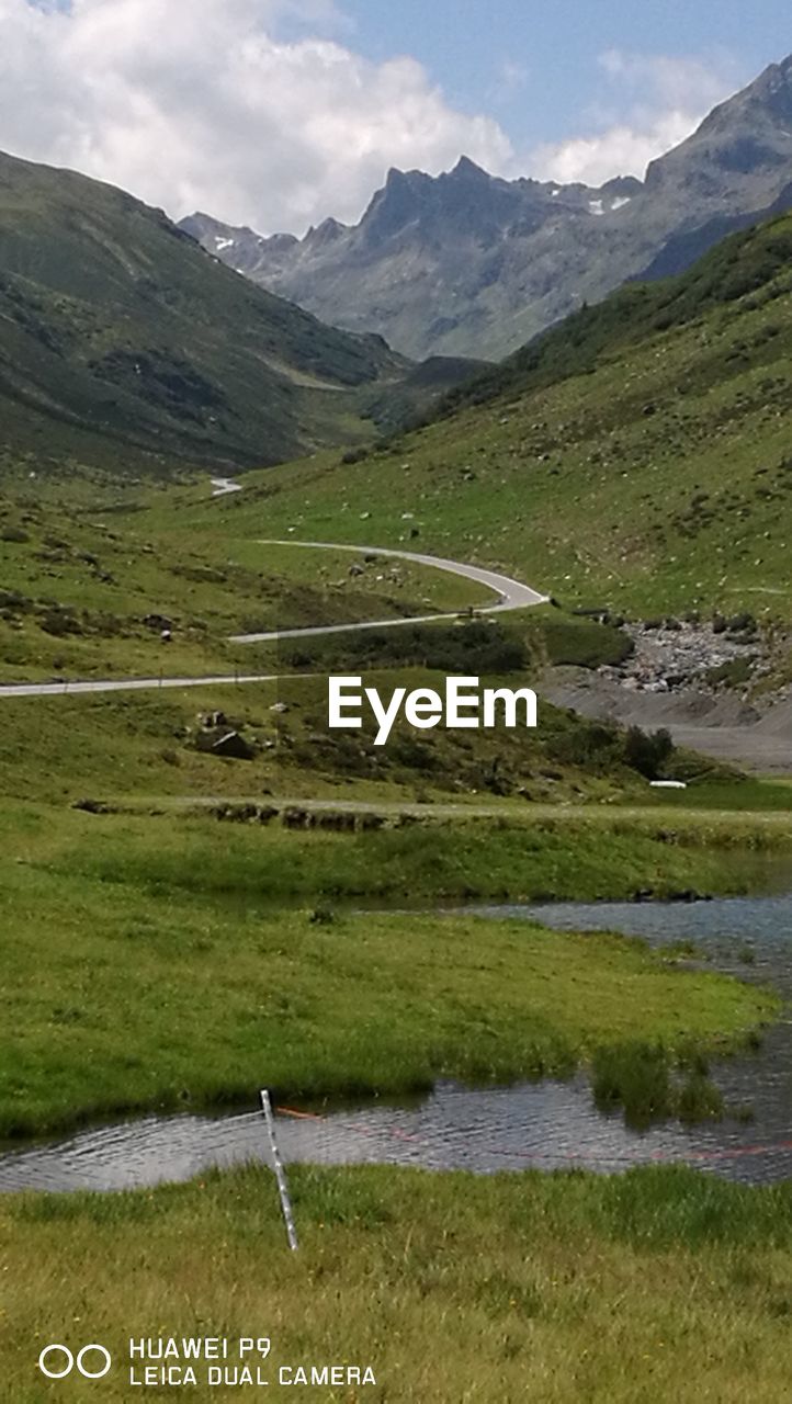 SCENIC VIEW OF GREEN LANDSCAPE AND MOUNTAINS