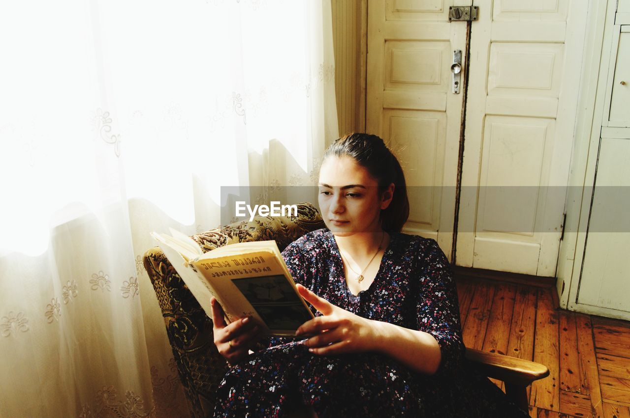 YOUNG WOMAN LOOKING AT BOOK