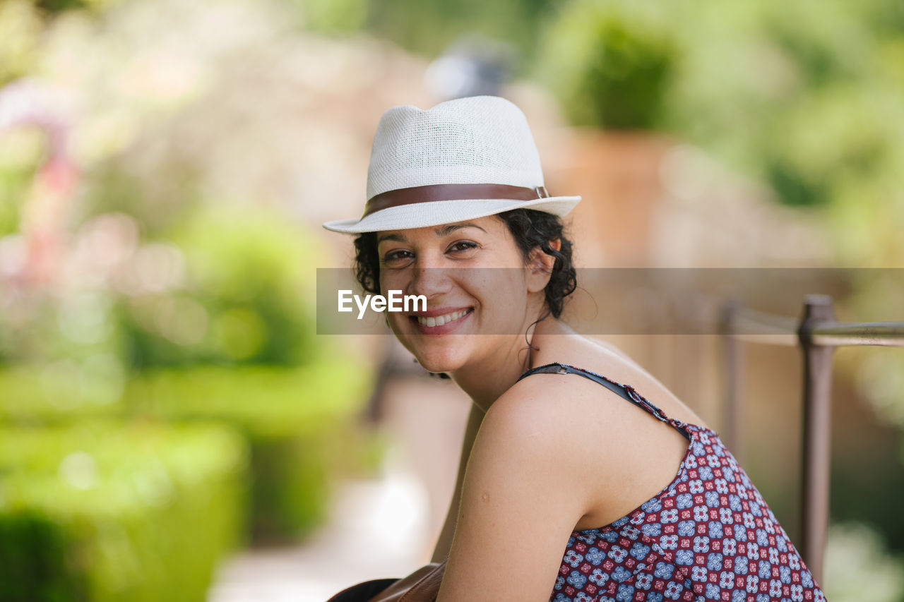 Portrait of smiling woman wearing hat outdoors