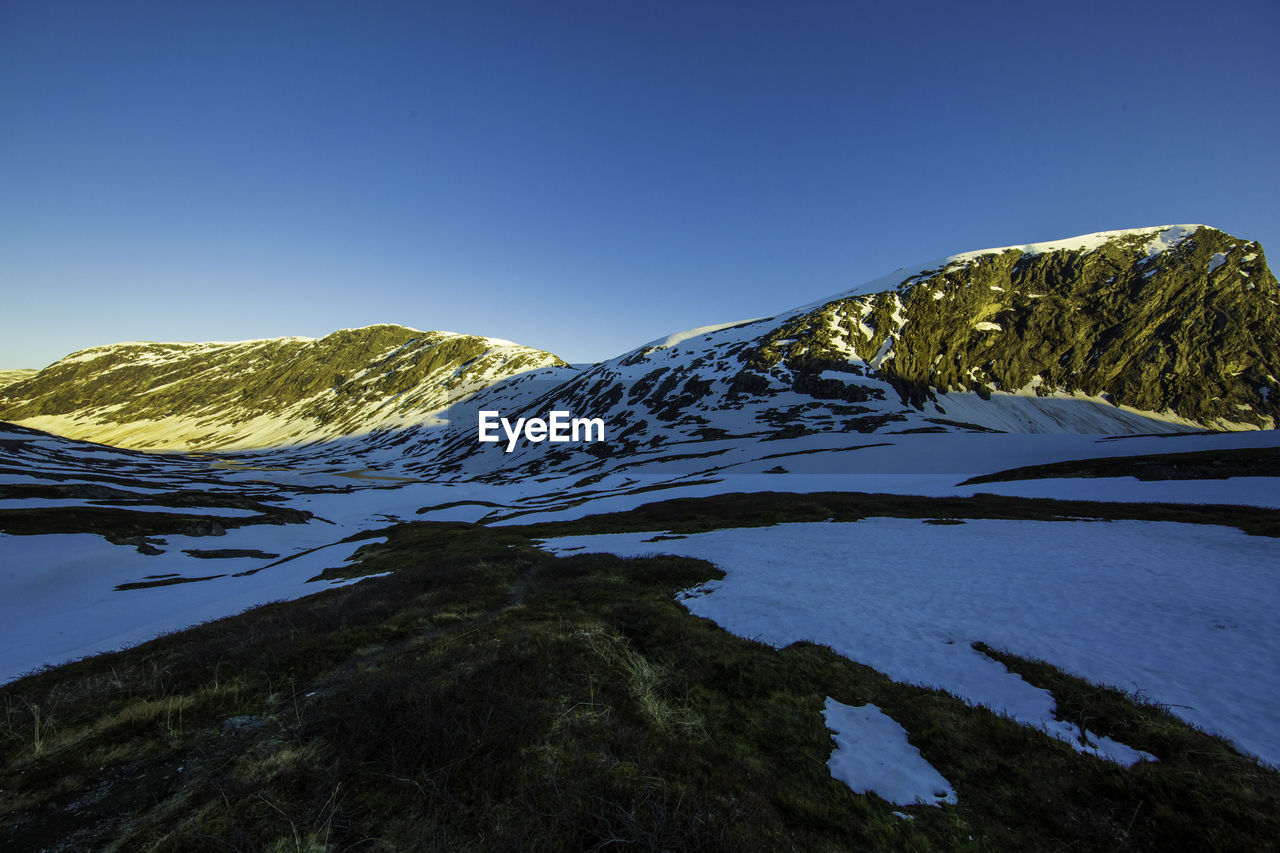 Scenic view of lake by mountain against sky