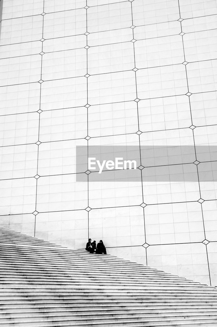 People sitting on staircase against wall