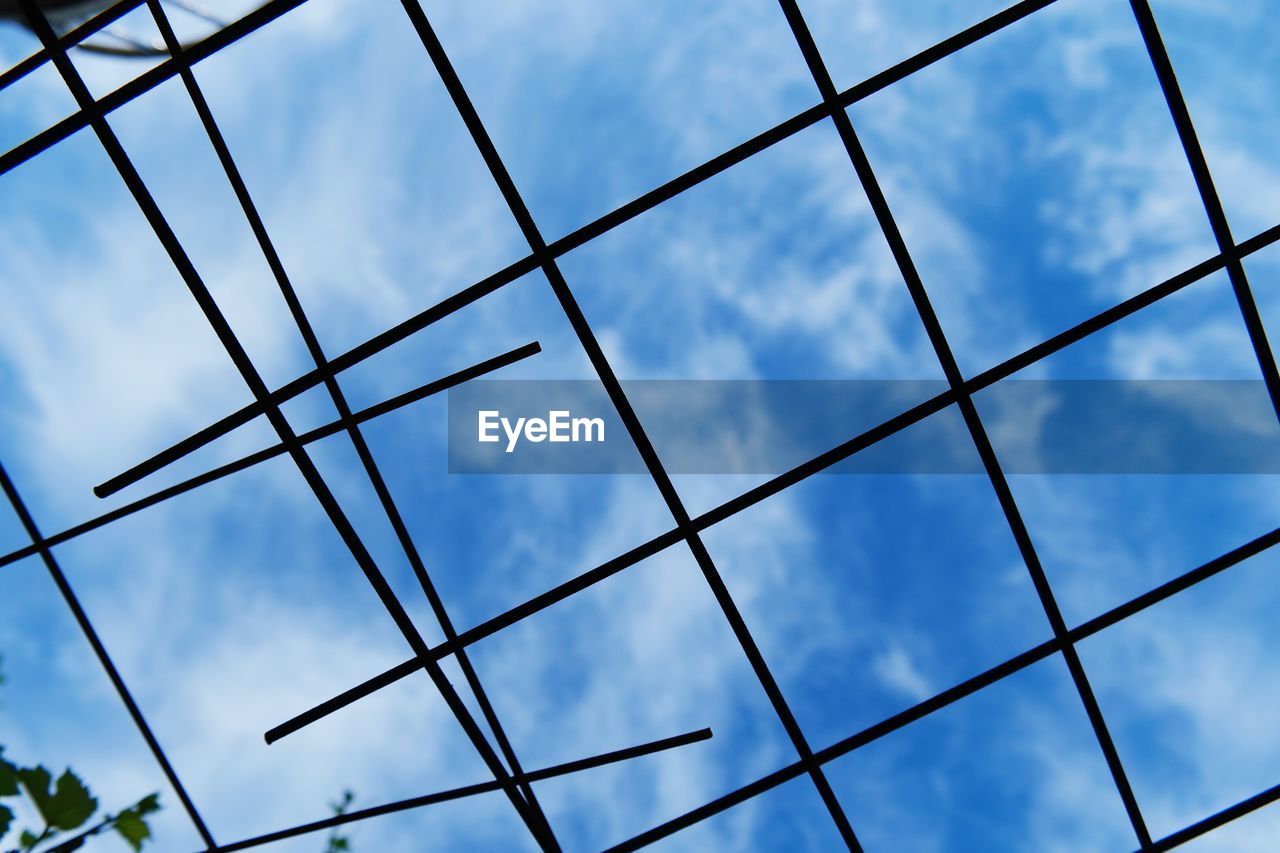 Low angle view of sky seen through metal rods