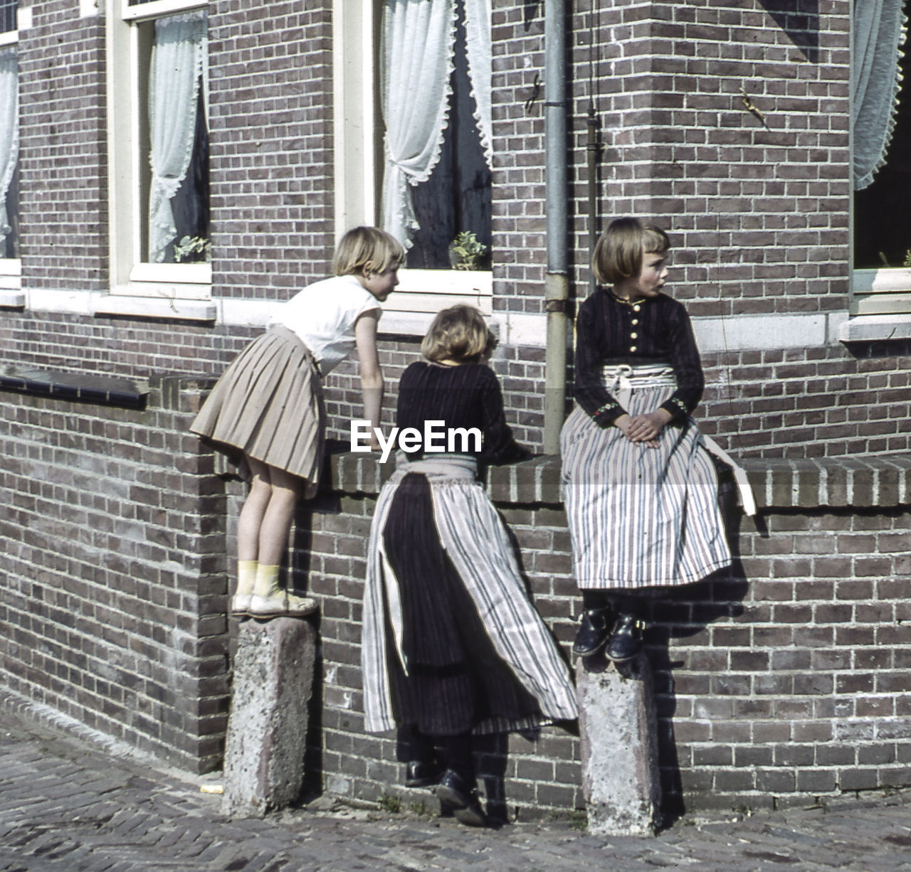 PEOPLE STANDING AGAINST BRICK WALL