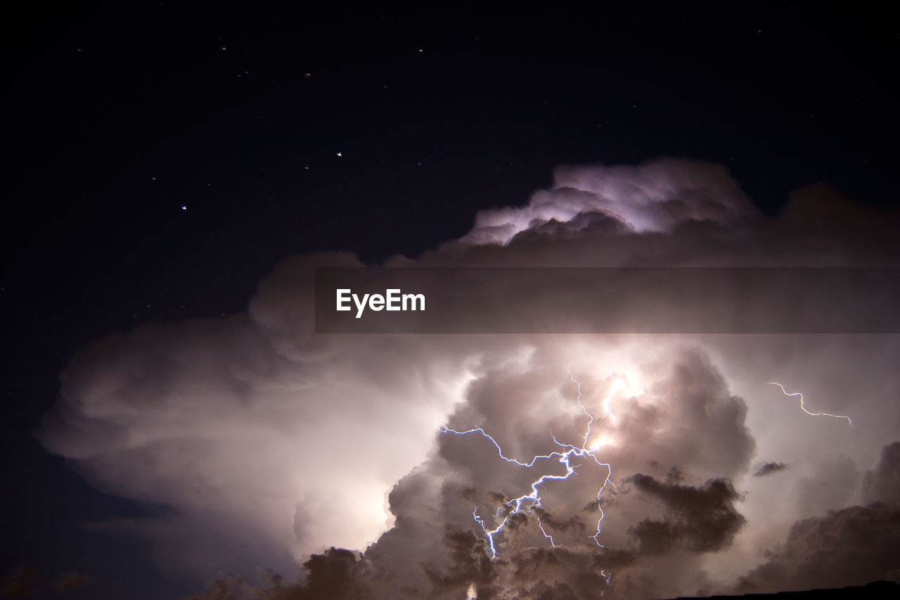 Low angle view of stormy clouds at night